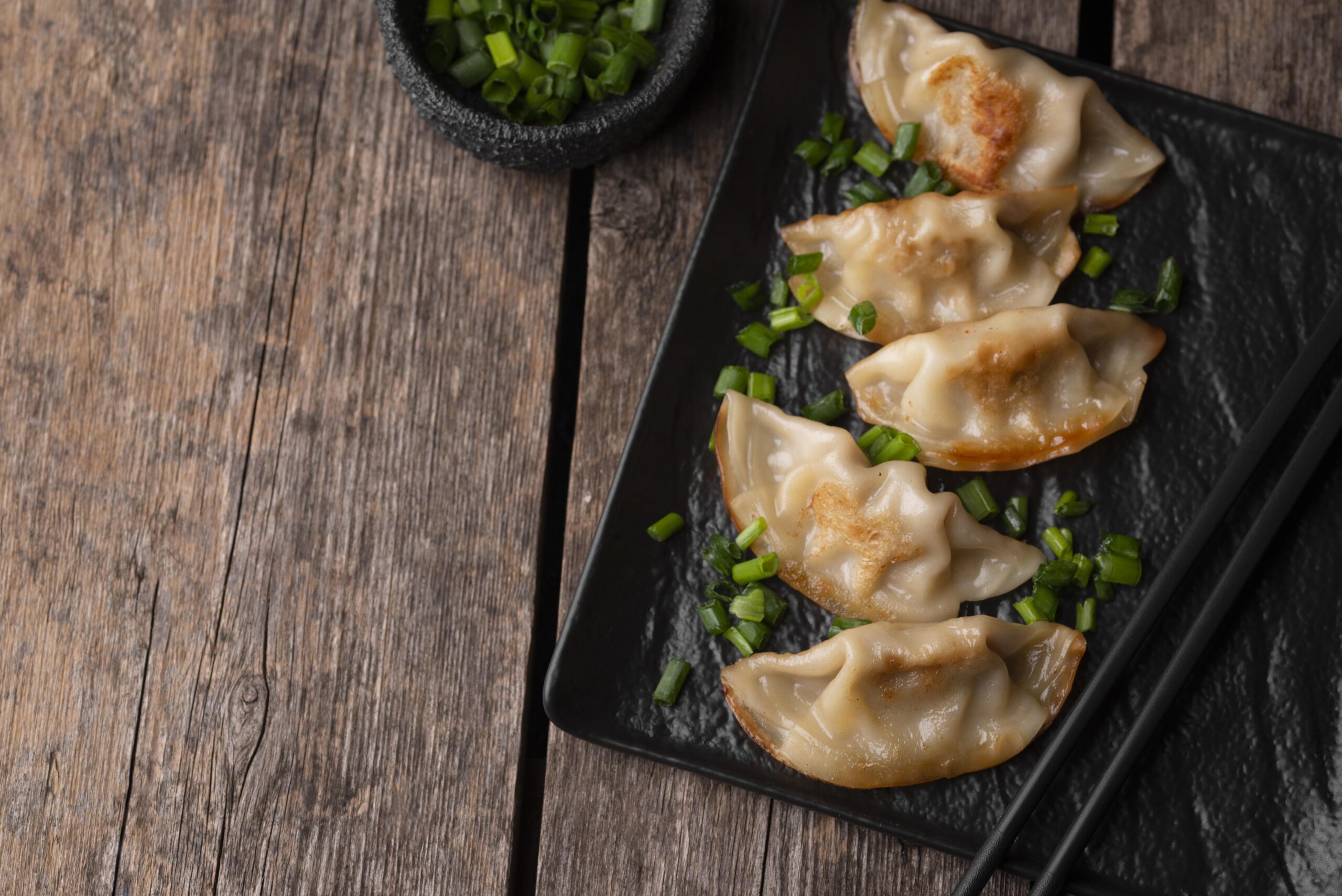 flat lay asian dumplings dish with herbs copy space scaled